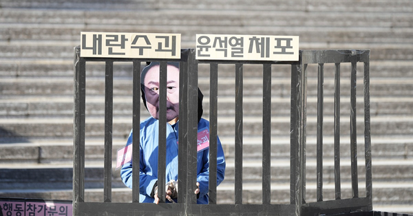 首爾有抗議民眾扮成總統尹錫悅，促他盡快辭職，而標語的意思為「拘捕尹錫悅」